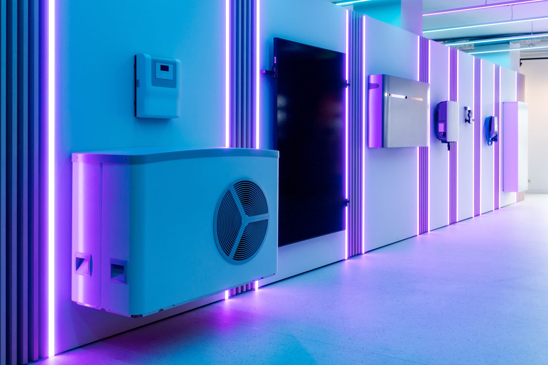 Futuristinen huone, jossa on seinällinen elektronisia laitteita ja hehkuvia violetin värisiä LED-valoja, luoden modernin ja korkean teknologian tunnelman.