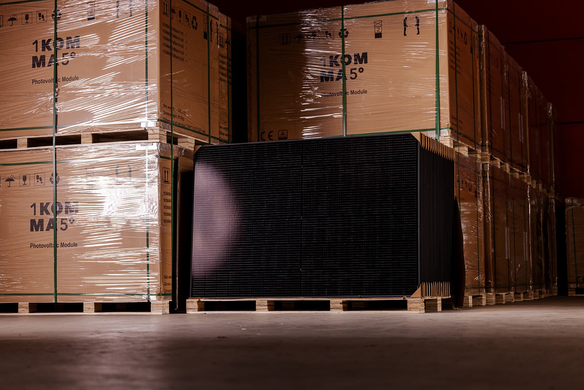 Moderni talo, jonka katolla on aurinkopaneelit, puisella terassilla ulkokalusteet ja nurmikkopihalla pieni katettu alue.