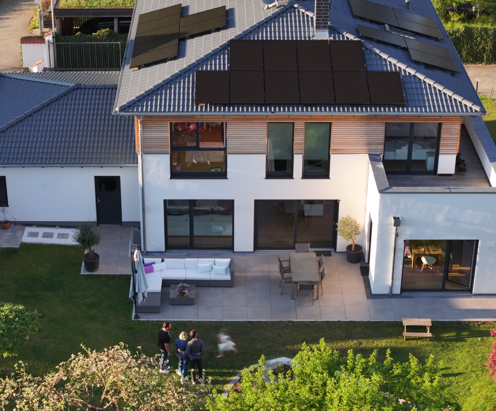 Kolme ihmistä 1KOMMA5°-näyttelytilassa, joka on sisustettu violetilla valaistuksella. Konsultti esittelee älypuhelinta kahdelle asiakkaalle – miehelle ja naiselle – keskustellen sen ominaisuuksista.