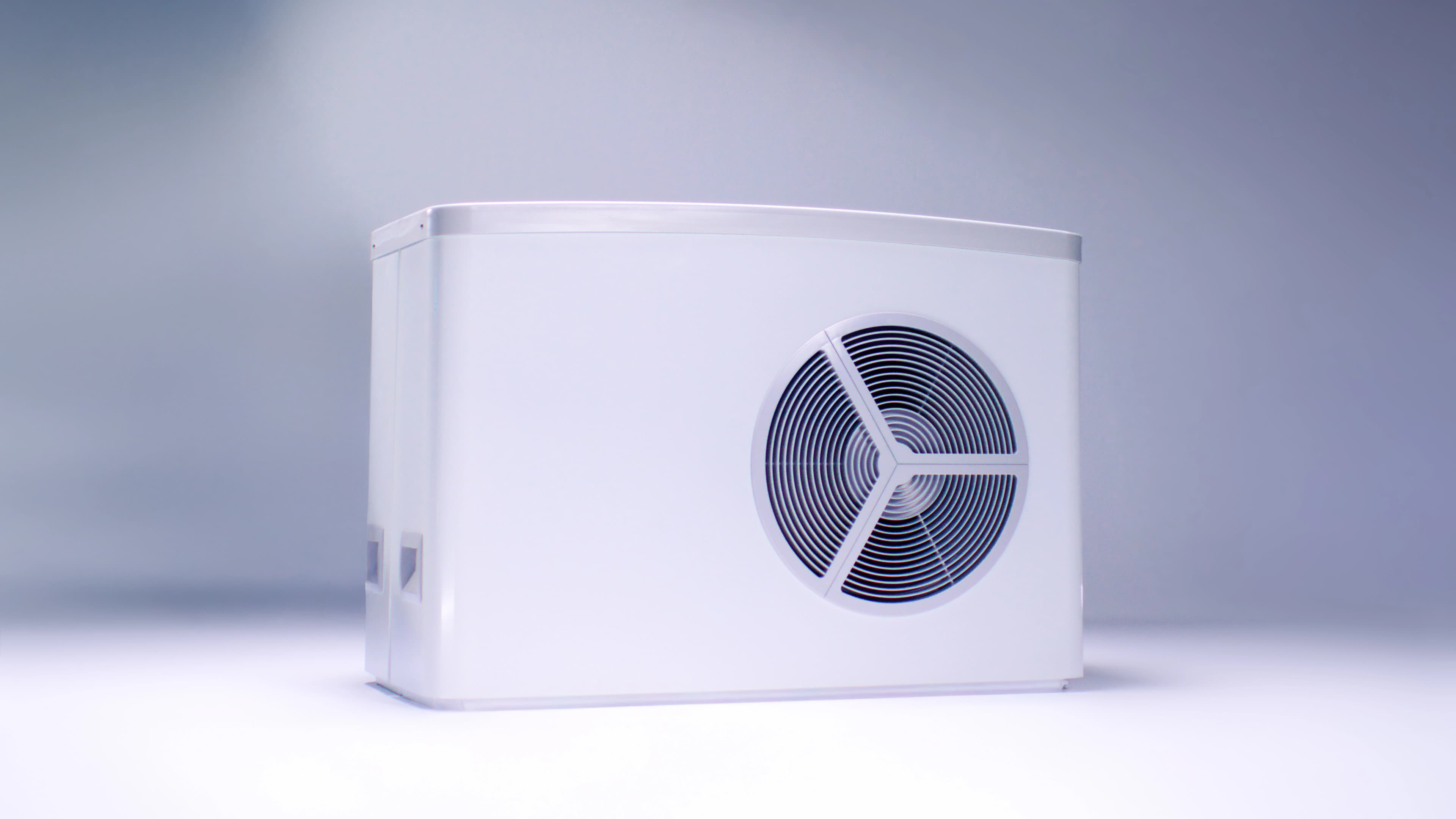 Neljä ihmistä tarkastelee ulkona olevaa lämpöpumppuyksikköä rakennuksen lähellä, yksi heistä pitelee esitettä.